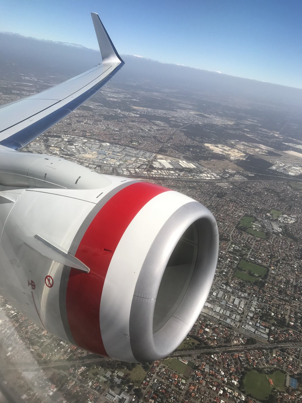 Aircraft wing and engine over a city on arrival