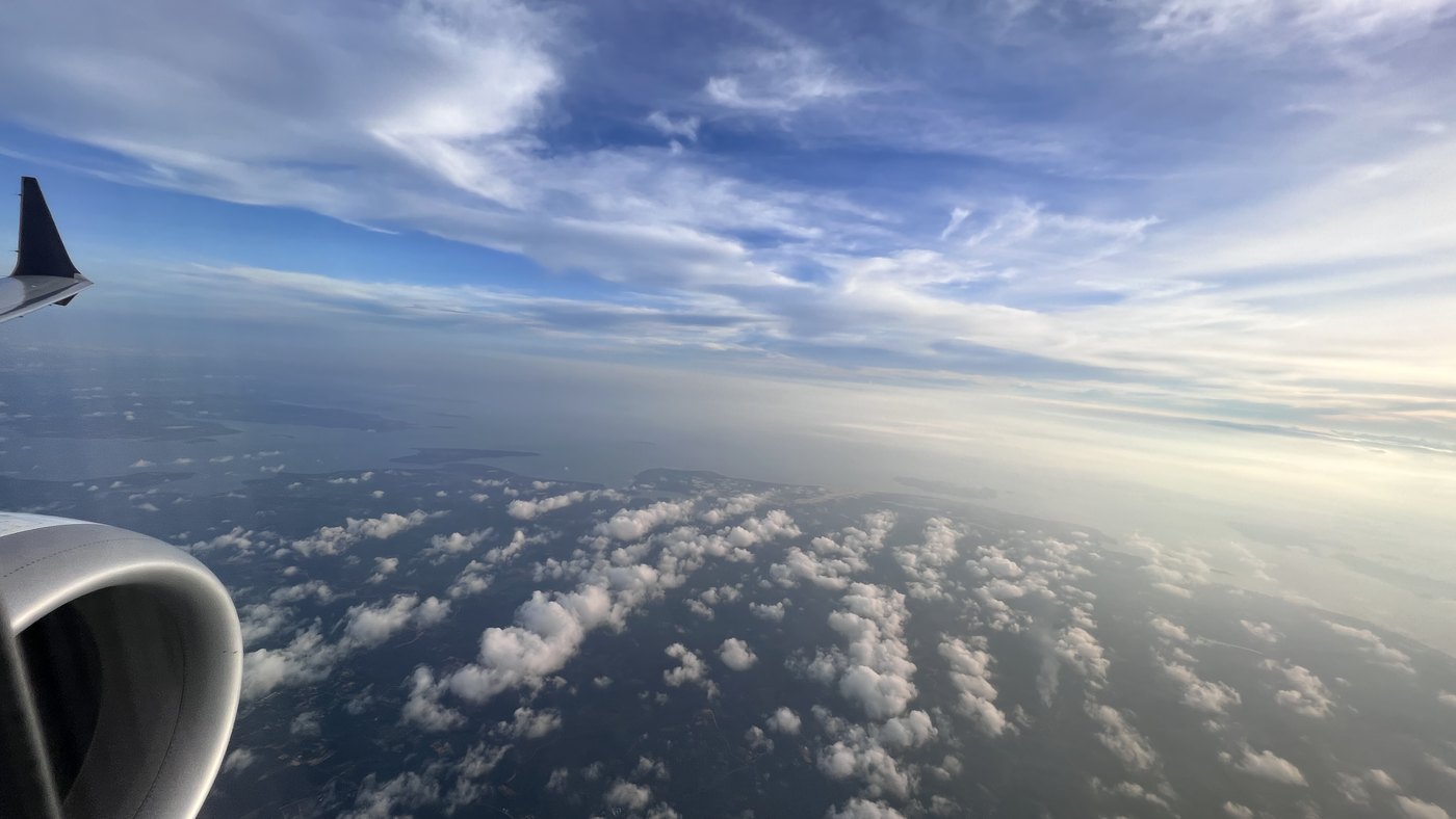 Aircraft wing over islands and coastline